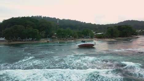 Drone-moving-around-a-shipwreck-in-front-of-the-beach-in-the-Caribbean-sea-in-Puerto-Viejo-de-Talamanca-in-Costa-Rica