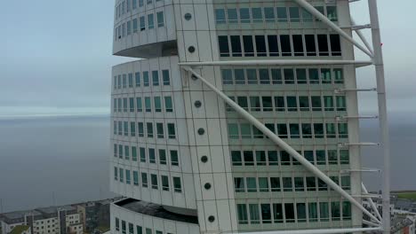 Jib-up-drone-shot-of-turning-torso-building,-neo-futurist-residential-skyscraper-ascending-aerial-close-up