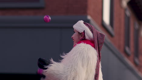 Woman-with-elf-ears-and-Santa-hat-juggles-balls-in-Christmas-Parade