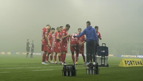 Professional-football-players-talking-and-drinking-water-during-match-break