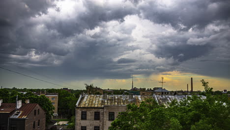 Dark-stormy-clouds-overcoming-sunshine-over-small-town,-time-lapse-view