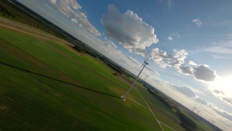 Wind-turbine-farm-on-sunny-day,-aerial-FPV-view