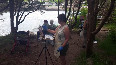 A-woman-with-easl-paints-a-seascape-at-the-Marginal-Way-Ogunquit,-Maine