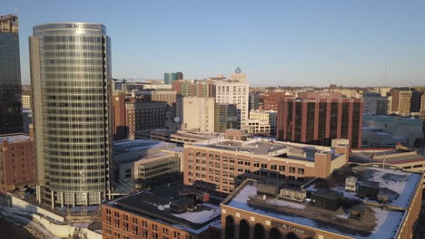 Aerial-push-out-shot-of-buildings-by-river-in-Grand-Rapids-on-winter-day