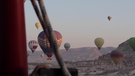 Hot-Air-Balloon-in-the-distance-with-a-clear-sky-and-mountains-in-the-background-in-Cappadocia-,-Turkey