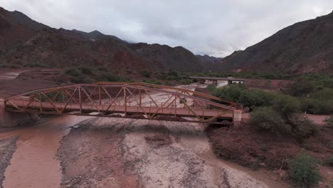 Un-Puente-Oxidado-Sobre-El-Lecho-De-Un-Río-Seco-En-La-Ruta-Escénica-68,-Quebrada-De-Las-Conchas,-Salta,-Vista-Aérea