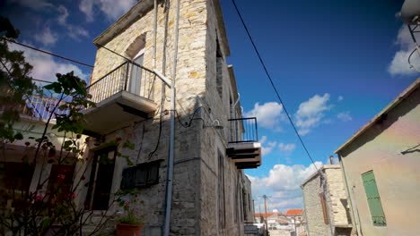 A-tall,-traditional-stone-house-with-balconies-and-blue-sky-backdrop