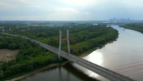 Aerial-panning-shot-of-traffic-on-Siekierkowski-bridge-with-skyline-of-Warsaw-in-background