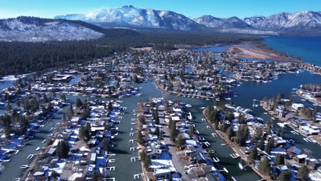 Aerial-View-of-Tahoe-Keys-on-Sunny-Winter-Day,-Homes-in-Canals-and-Snow-Capped-Peaks-Above-Lake-Tahoe,-California-USA
