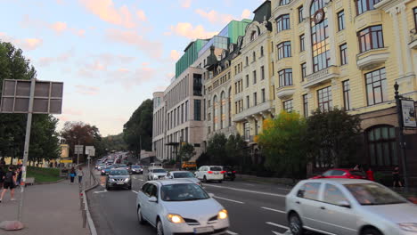 Straße-Mit-Fahrenden-Autos-Und-Gebäuden-In-Der-Stadt-Kiew,-Ukraine,-Menschen-Gehen-Zu-Fuß,-4k-Aufnahme