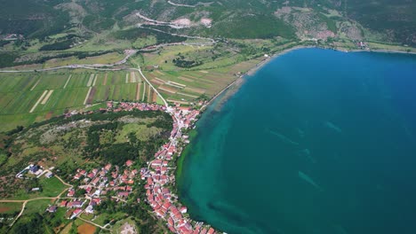 Beautiful-Shoreline-of-Lake-Ohrid-with-Vineyards-and-the-Picturesque-Fishing-Village-of-Lin-on-the-Peninsula,-Pogradec,-Albania