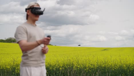 Piloto-De-FPV-Vuela-Drone-Sobre-El-Floreciente-Campo-De-Colza,-Oscura-Nube-De-Tormenta-Detrás