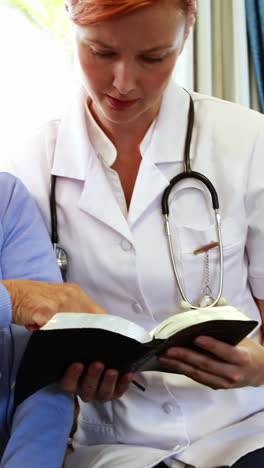 Senior-woman-and-nurse-reading-a-book-together
