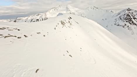 Menschen,-Die-Schneebedeckte-Berge-Norwegens-Hinunterfahren,-FPV-Luftansicht