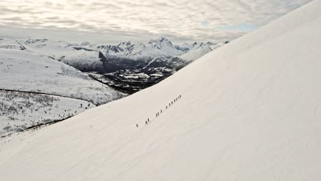 Gruppe-Von-Menschen-Wandern-Auf-Weißen-Schneebedeckten-Bergen,-Luftaufnahme