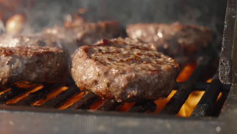 Close-Up-of-Flame-Grilled-Sizzling-Barbecued-BBQ-Beef-Burgers-in-Slow-Motion