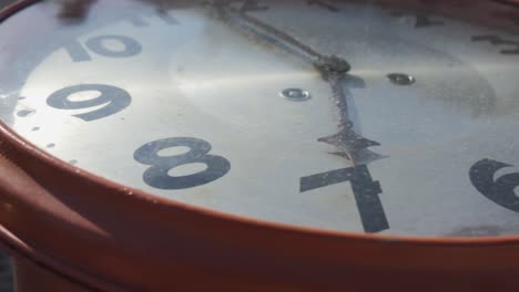 Arcing-medium-close-up-of-old-clock-face-in-bright-sunlight-at-Dutch-angle,-stuck-at-number-7