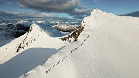 Riesige-Gruppe-Von-Menschen,-Die-Zum-Skifahren-Einen-Schneebedeckten-Berg-Hinaufklettern,-Luftaufnahme