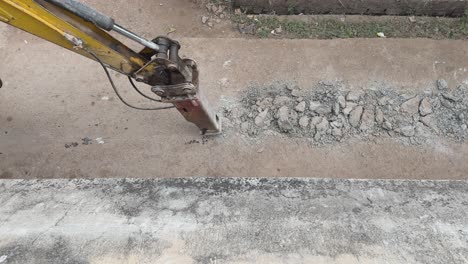 Excavadora-Rompiendo-Y-Perforando-El-Camino-De-Concreto-Para-Reparar-La-Línea-De-Alcantarillado-O-La-Varilla