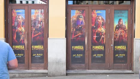 A-moviegoer-enters-a-cinema-adorned-with-advertisement-posters-for-the-film-'Furiosa:-A-Mad-Max-Saga,'-a-post-apocalyptic-action-film-directed-and-produced-by-George-Miller