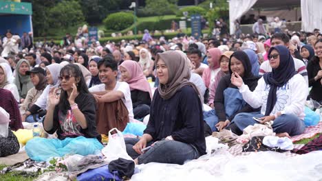 Indonesian-Young-People-Sitting-On-Ground,-Watching-Outdoor-Concert