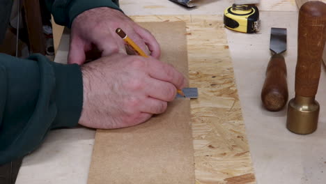 The-carpenter-marks-the-workpiece-with-a-right-angle-and-pencil