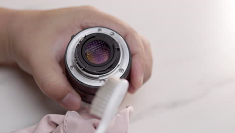Close-up-of-hand-cleaning-camera-ring-with-toothbrush-and-flannel-cloth