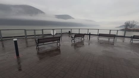 Benches-on-the-Cold-Spring,-New-York-waterfront-on-a-very-rainy,-atmospheric-and-foggy-day-with-the-Appalachian-mountains-and-Hudson-River-in-the-background