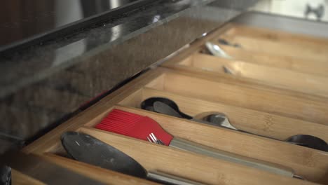 Grabbing-a-utensil-out-of-a-kitchen-drawer