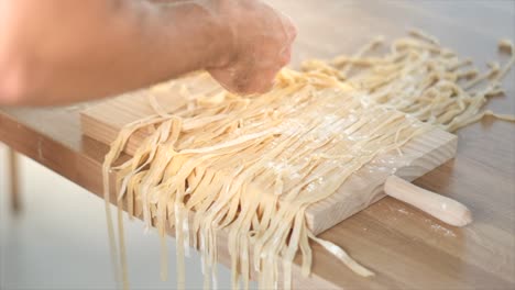 Homemade-pasta-being-prepared-on-wooden-cutting-board