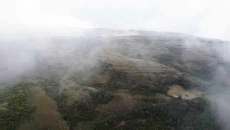 Backward-drone-view-of-capturing-hills-on-a-foggy-morning