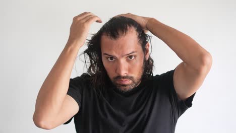 latino-man-checking-his-hair-with-receding-hairline-and-baldness,-Thinning-hair
