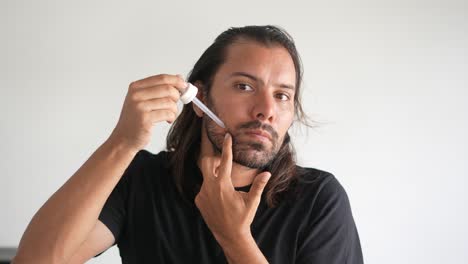 man-applying-minoxidil-to-his-beard-with-a-dropper,-Liquid-formula
