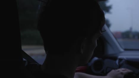 Young-man-driving-car-at-night,-close-up