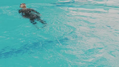 Junge-Asiatische-Amateurschwimmerin-Macht-Rückenschwimmen-Im-Schwimmbad