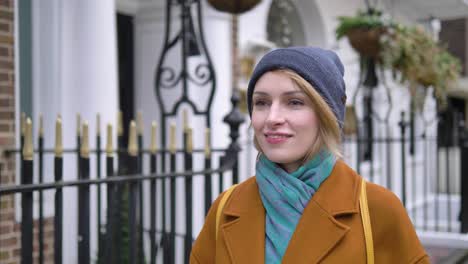 Happy-cheerful-positive-and-relaxed-young-Caucasian-woman-enjoying-the-weather,-walking-down-a-London-street-and-smiling-while-looking-around
