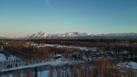 Alaska-landscape-during-sunset-with-cabins-in-the-foreground-and-mountains-in-the-back-ground