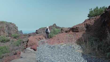 Female-hiker-walking-over-a-rocky-path-in-Teno-mountains,-Tenerife