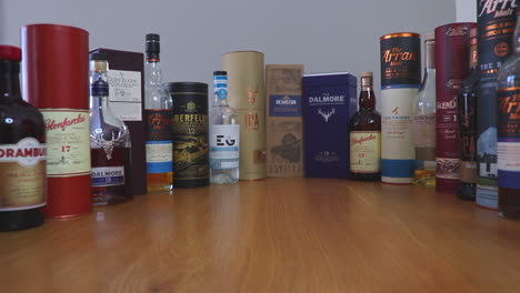 Zooming-out-to-a-selection-of-Scottish-Whiskies-and-Scottish-Gins,-including-single-malt-Scotch-whiskies,-bottles-and-packaging