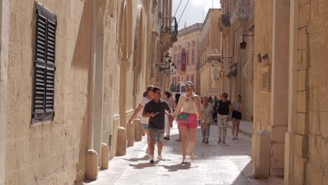 Los-Viajeros-Y-Visitantes-Exploran-Tranquilamente-Las-Pintorescas-Y-Estrechas-Calles-De-Mdina,-Malta,-Sumergiéndose-En-Su-Encanto-Histórico-Y-Belleza-Arquitectónica.
