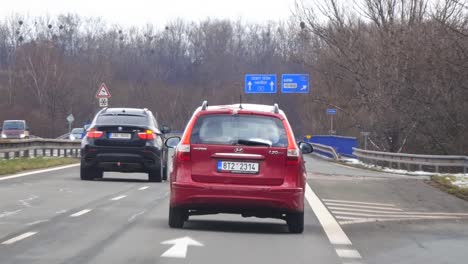 Red-Hyundai-i30-CW-estate-car-on-highway,-rear-view-with-slow-motion