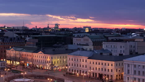 Iconic-Helsinki-waterfront-buildings-illuminated-at-twilight,-aerial-trucking