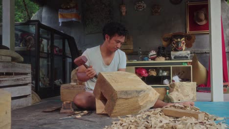 Indonesian-man-sitting-at-home-carving-in-solid-wood