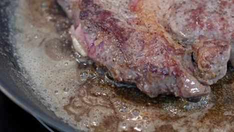 Closeup-of-beef-edge-frying-in-hot-pan,-browned-on-top-with-red-meat-below,-detailed-texture-visible-60-fps