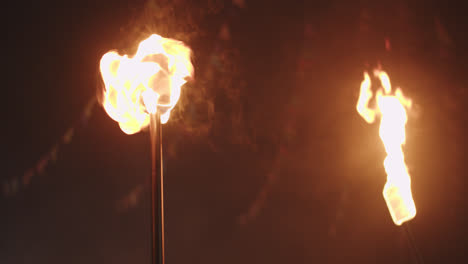 Beautiful-slow-motion-shot-of-fire-in-torches-during-a-theatrical-exhibition-outside-a-town-square-in-southern-Spain,-Andalusia