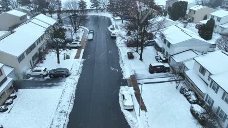 Aerial-flyover-snowy-housing-area-during-snowfall-in-America