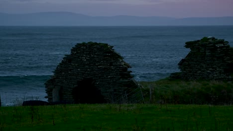 Old-abandon-coastal-hut-before-sunrise,-on-a-farm-in-Scotland