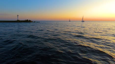 Sailboat-sailing-in-the-sea-to-watch-the-sunset