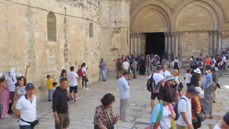 Numerous-tourists-walk-at-the-entrance-to-the-Holy-Sepulchre-in-the-Old-City-in-Jerusalem,-Israel