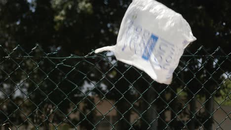 A-single-plastic-shopping-bag-caught-on-a-fence-and-blowing-in-the-wind